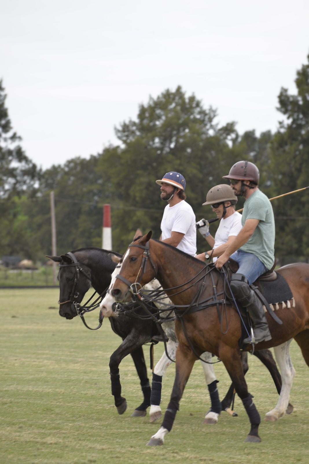 Tres jugadores a caballo, juntos, después de la práctica.